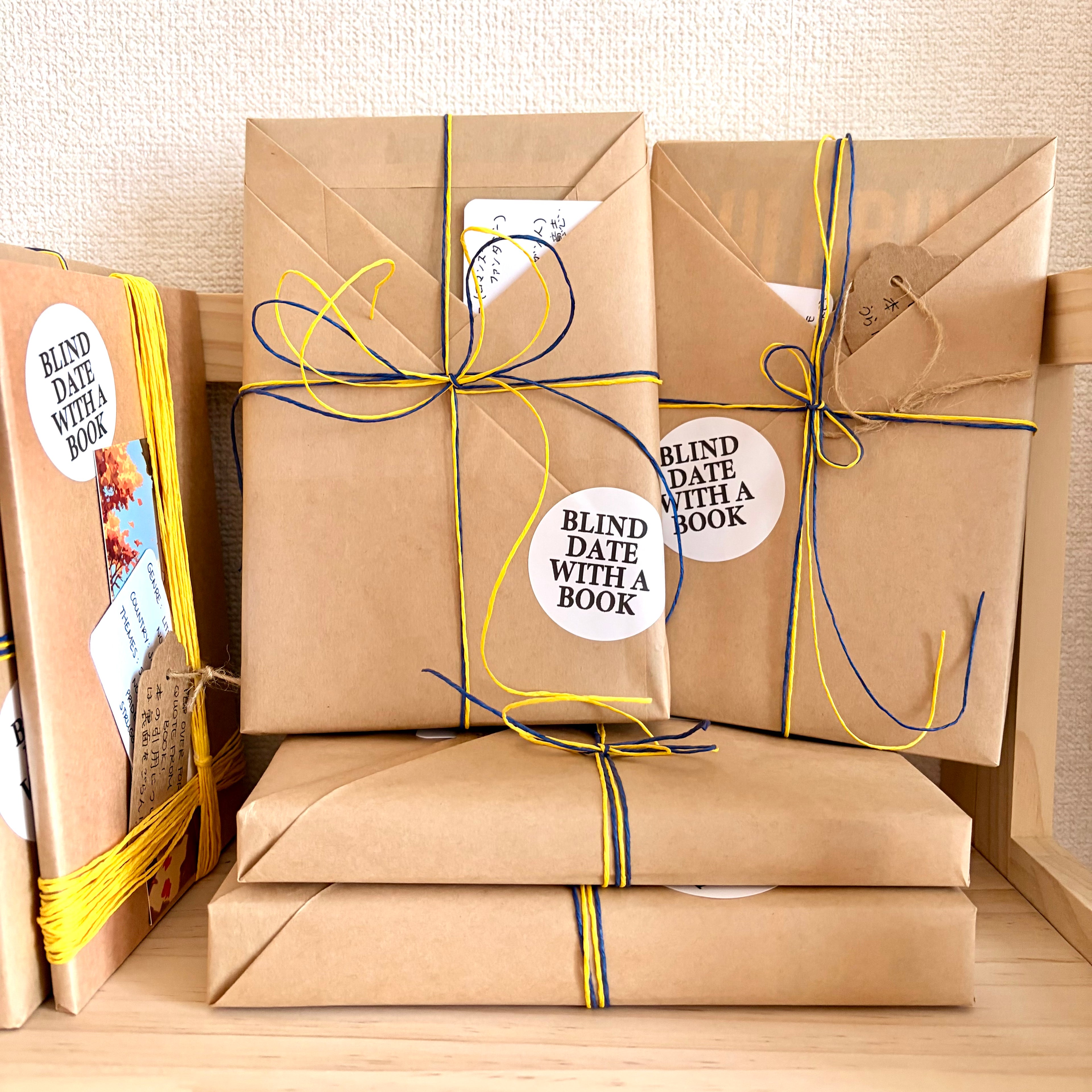 Books wrapped in kraft paper with yellow and blue ribbons and 'Blind Date with a Book' labels.